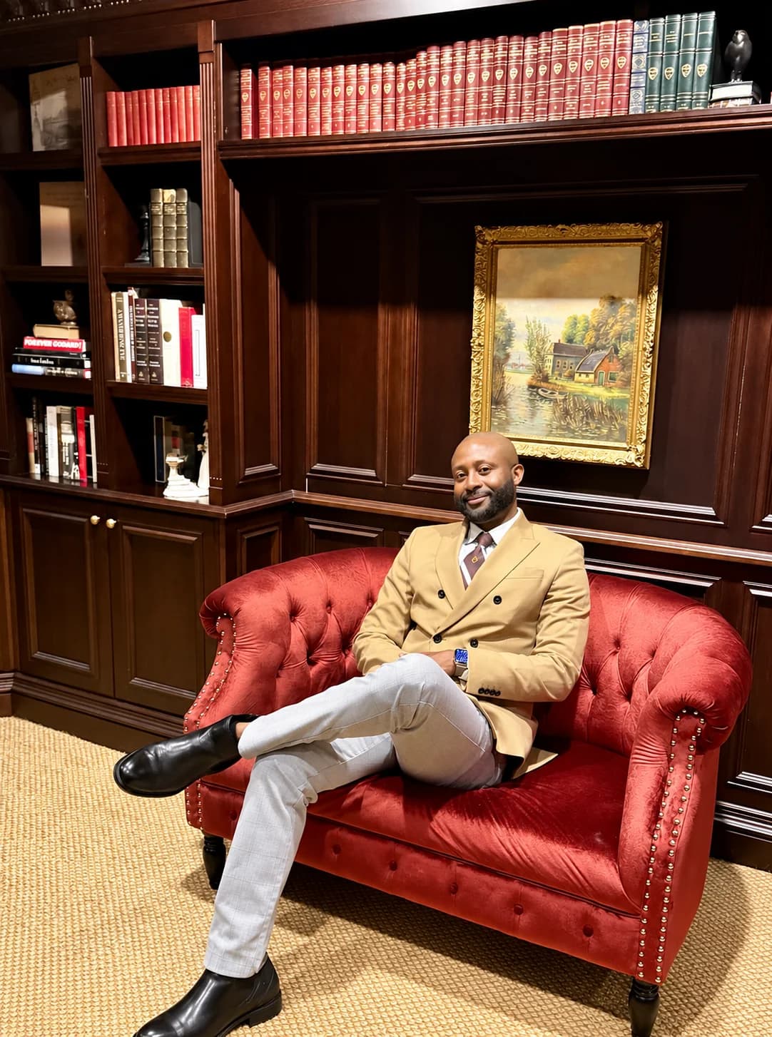 Alexander Azenabor, founder of PracticeNerds, seated in a wood-paneled library.